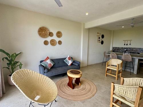 Una sala de estar con un sofá y sillas y una mesa. en Casa Zianda - Departamentos en Puerto Escondido, en Brisas de Zicatela