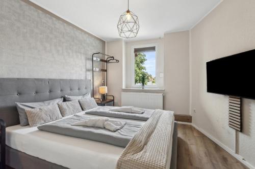 a bedroom with a large bed and a tv at Bergblick - Wasserlage - Parkplatz - Harzduft in Thale
