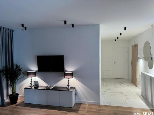 a living room with a tv on a white wall at AMuSE ME in Kielce