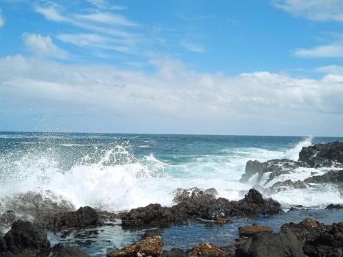 a wave crashing on the rocks in the ocean at Un jardin al mar in Genovés