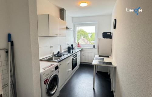 a kitchen with a washer and a sink and a refrigerator at BEGE APARTMENTS Corporate Hub in Lüdenscheid