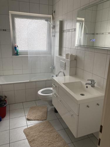 a bathroom with a sink and a toilet and a window at Rentarooms A in Oebisfelde