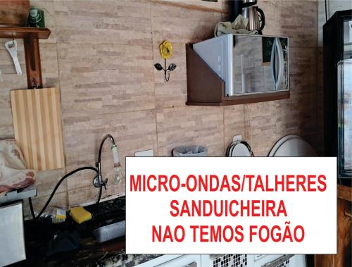 a kitchen with a sink and a microwave on a wall at Pousada Mirante da Serra Fonte Sônia-Valinhos in Valinhos