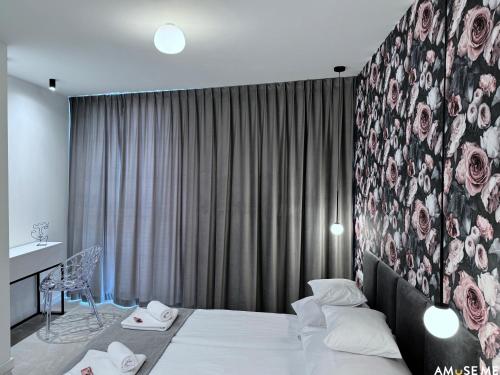 a hotel room with a bed and a wall with roses at AMuSE ME in Kielce