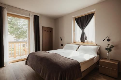 a bedroom with a large bed and a window at Bonvivar - Mountain Guesthouse in Livigno