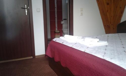 a hotel room with a bed with towels on it at Vila Moecel in Moieciu de Sus