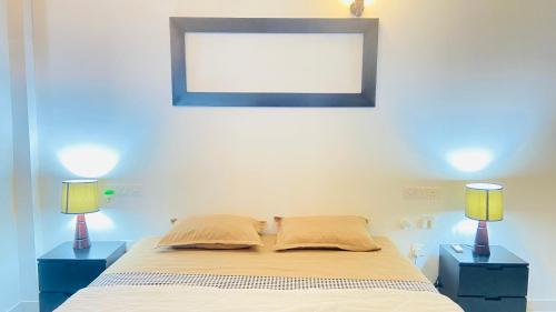 a bedroom with a bed with two blue night stands at Erin Orr Villa in Wadduwa