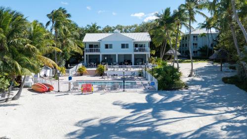 a house on a beach with palm trees at Bayside Inn Key Largo in Key Largo