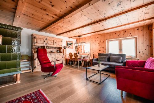 a living room with red chairs and a couch at Casa Marie in Malans