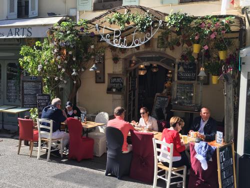 a group of people sitting at tables outside a restaurant at Villa Oleander, Mougins in Mougins