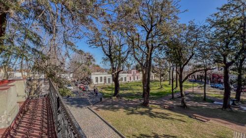 a park with trees in front of a building at Viajero Colonia Hostel in Colonia del Sacramento