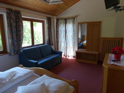 a hotel room with a bed and a blue couch at Residence Blumenthalerhof in Lagundo