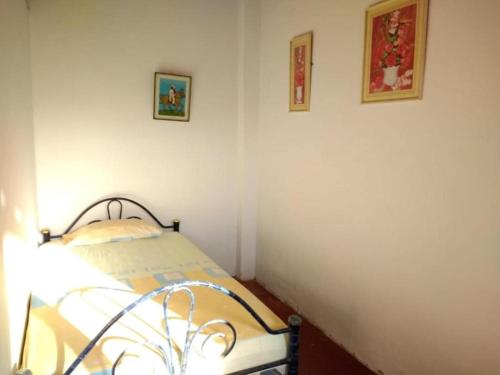 a bedroom with a bed and two pictures on the wall at Hospedaje Costa Norte in Máncora