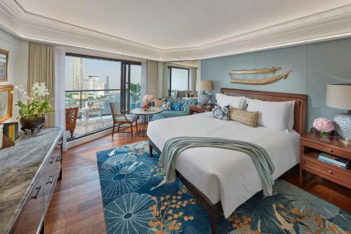 a bedroom with a large bed and a living room at Mandarin Oriental, Bangkok in Bangkok