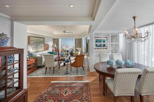 a dining room and living room with a table and chairs at Mandarin Oriental, Bangkok in Bangkok