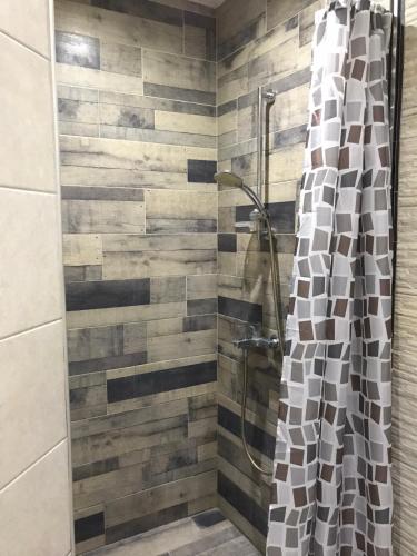 a shower with a glass curtain in a bathroom at Ssenyange Sea View Apartment in Varna City