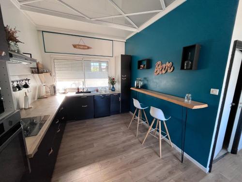 a kitchen with blue walls and a counter with stools at La Verrière Berges du Tarn - Centre historique in Millau