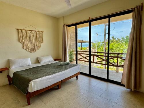 a bedroom with a bed and a large window at Casa Zianda - Departamentos en Puerto Escondido in Brisas de Zicatela