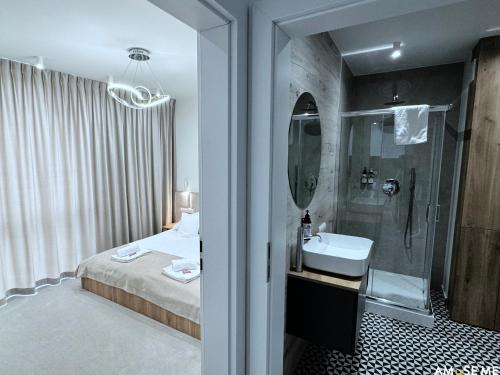 a bathroom with a bed and a sink and a shower at AMuSE ME in Kielce