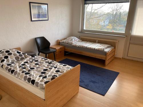 una camera da letto con un letto, una sedia e una finestra di Rentarooms B a Oebisfelde
