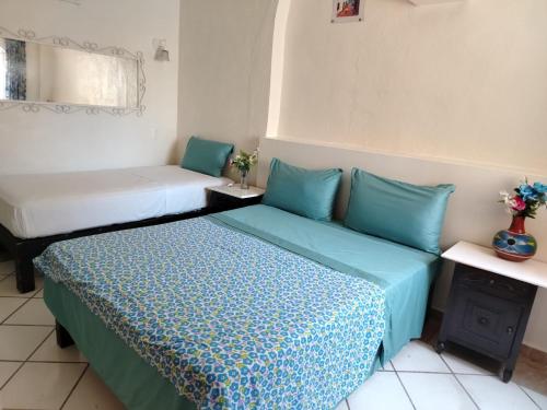 a room with two beds with blue pillows at Alexandross in Puerto Vallarta