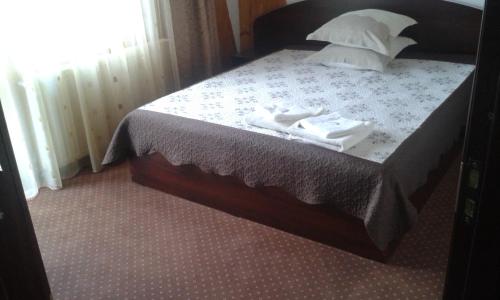 a bedroom with a bed with two towels on it at Vila Moecel in Moieciu de Sus