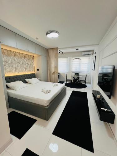a bedroom with a large bed and a table at A'dors Apartments in Skopje