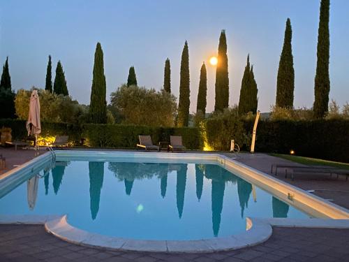 a large swimming pool with trees in the background at Ghiaccio Bosco in Capalbio