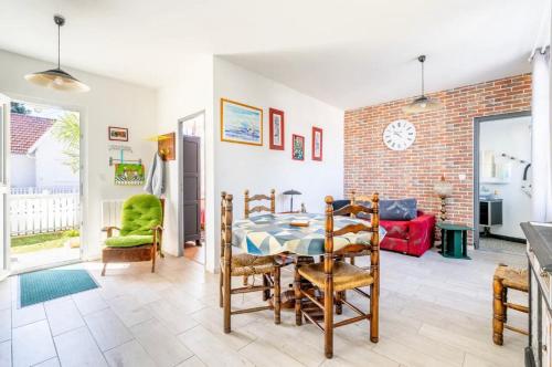 d'une salle à manger avec une table, des chaises et un mur en briques. dans l'établissement KY-Ryce 4 personnes, à Tharon-Plage