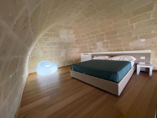 a bedroom with a bed and a brick wall at Giardini di Luce in Matera