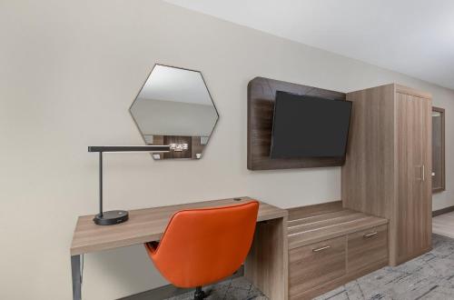 a room with a desk with a television and a chair at Holiday Inn Express Hurricane Mills Waverly by IHG in Hurricane Mills