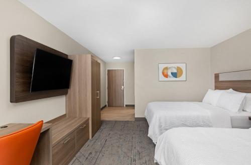 a hotel room with two beds and a flat screen tv at Holiday Inn Express Hurricane Mills Waverly by IHG in Hurricane Mills