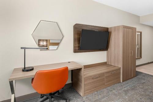 a room with a desk and a tv and a chair at Holiday Inn Express Hurricane Mills Waverly by IHG in Hurricane Mills