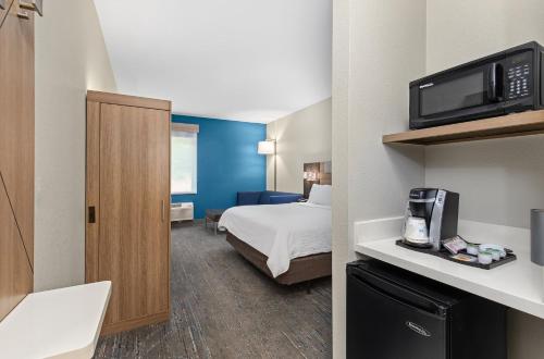 a hotel room with a bed and a microwave at Holiday Inn Express Hurricane Mills Waverly by IHG in Hurricane Mills