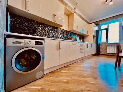 a kitchen with a washer and dryer in a room at Secrets Apartment in Baku