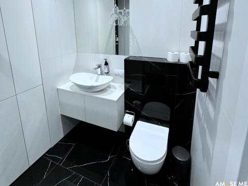 a white bathroom with a sink and a toilet at AMuSE ME in Kielce