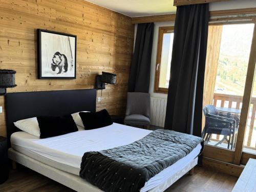 une chambre avec un lit dans une pièce aux murs en bois dans l'établissement Résidence Le Centaure - 4 Pièces pour 8 Personnes 591, à Aime La Plagne