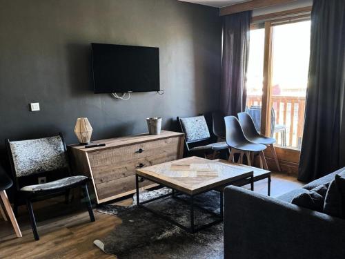 un salon avec une télévision à écran plat au mur dans l'établissement Résidence Le Centaure - 4 Pièces pour 8 Personnes 591, à Aime La Plagne