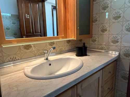 Un mostrador de baño con un lavabo y un espejo. en Artemis Airport Stay, en Artemida