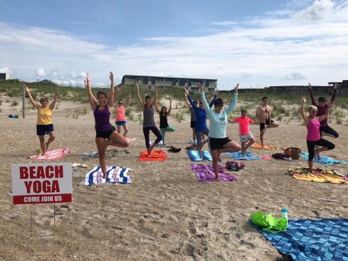 a group of people doing yoga on the beach at A Place at the Beach III in Atlantic Beach