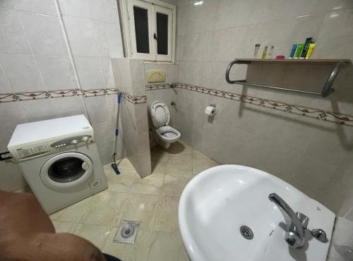 ein Badezimmer mit Waschbecken und Waschmaschine in der Unterkunft Happy home in Hurghada