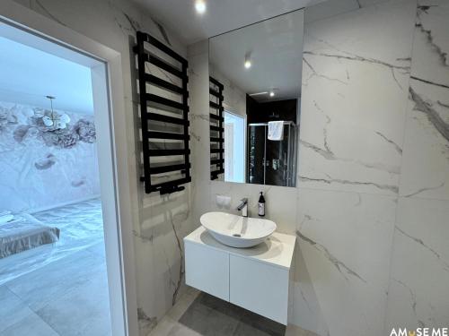 a white bathroom with a sink and a mirror at AMuSE ME in Kielce
