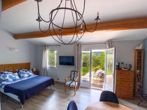 - une chambre avec un lit bleu et un lustre dans l'établissement la chamade grande chambre B&B indépendante, à Ventabren