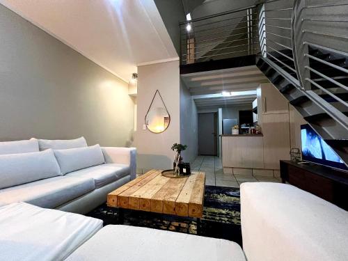 a living room with a couch and a coffee table at Sandton - Japandi style 1 bedroom Loft apartment in Sandton