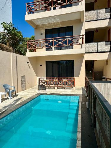 a house with a swimming pool in front of a building at Casa Zianda - Departamentos en Puerto Escondido in Brisas de Zicatela