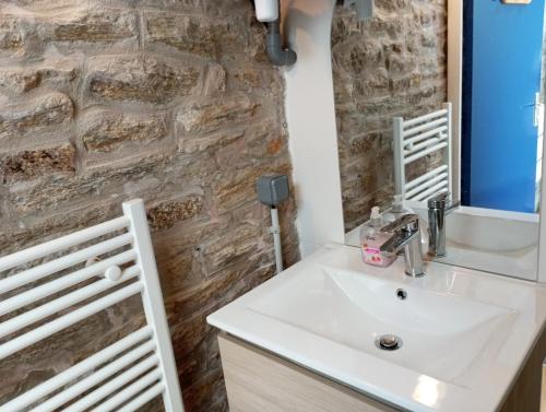 コンカルノーにあるLe Cocon de Renée, Maison atypique en ville close de Concarneauの洗面台と石の壁のあるバスルーム