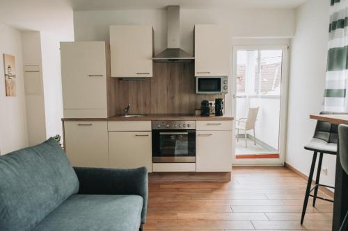 a living room with a couch and a kitchen at Apartment ELISA in Klagenfurt