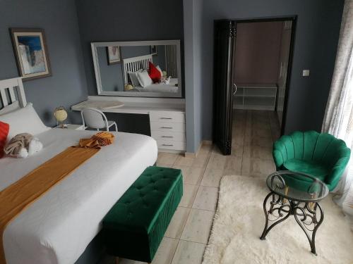 a bedroom with a bed and a green chair at Minnestay Guest House Palapye in Palatswe