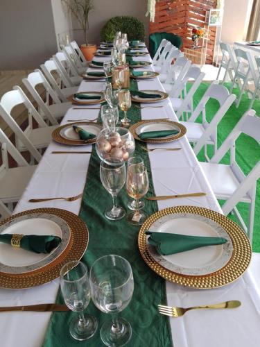 a long table with plates and wine glasses on it at Minnestay Guest House Palapye in Palatswe