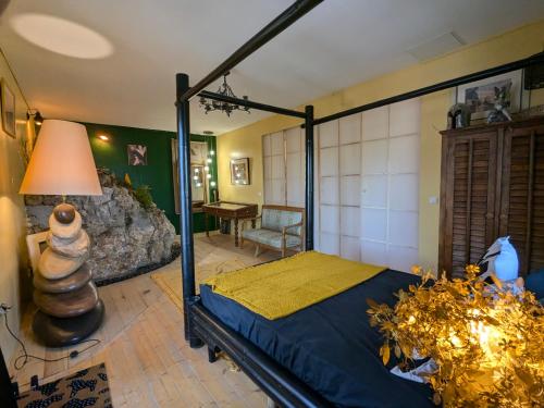a bedroom with a bed and a table in a room at Charme, vue et piscine naturelle in Vedène